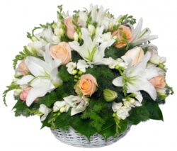 Round wicker basket with lilies and roses