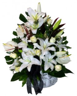 Wicker basket with anthurium, lilium and white roses